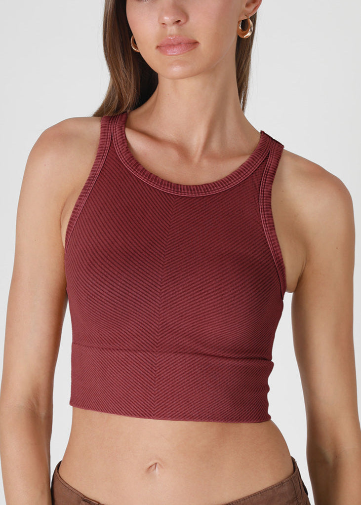 Woman wearing a maroon tank top on a white background