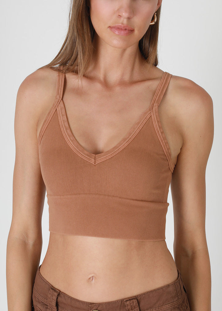Woman wearing a brown crop top and pants on a white background