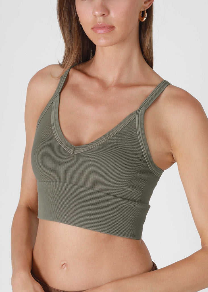 Woman wearing a green crop top against a white background